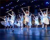 Dancers dressed in white with canes